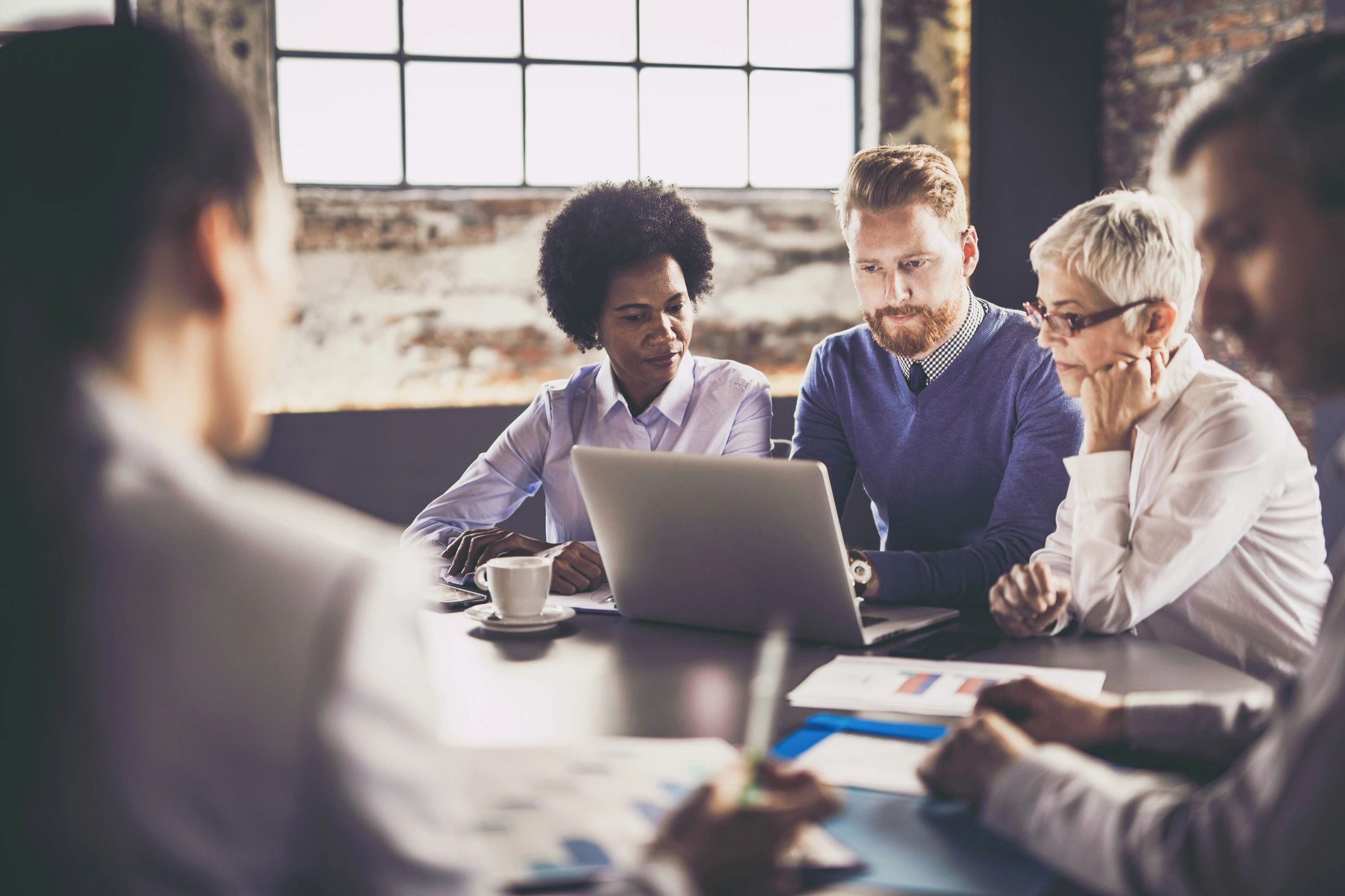 Team reviewing security notes on a laptop during a meeting
