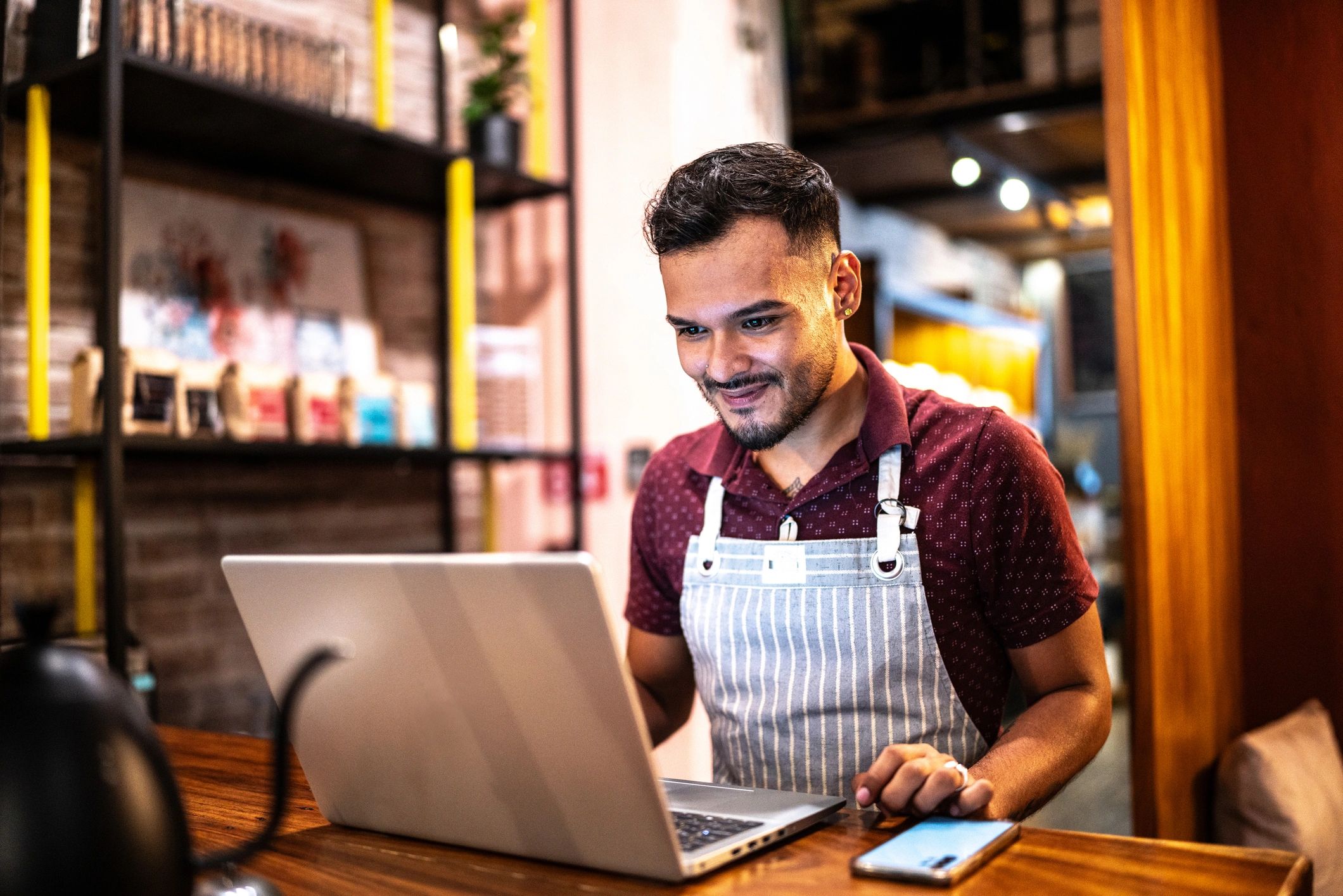 Small business owner working on a laptop in a cafe