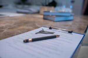 Close-up real estate purchase agreement with pen and house keys